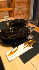 a table with a black plate and glasses on a table at Star Cottage in Bajina Bašta +5 photos