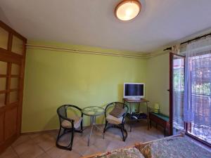 a room with a table and chairs and a tv at Apartments Grace in Rovinj