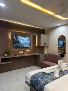 a bedroom with a bed and a tv on the wall at Hotel The Avanta- Naroda in Naroda