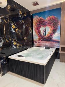 a hot tub in a room with a heart wall at Hotel The Avanta- Naroda in Naroda
