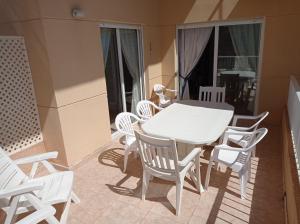 a white table and chairs on a balcony at Parquemar III-IV Solo Familias!!! Serviplaya in Playa de Xeraco