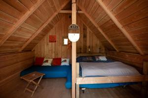a bedroom with a bed in a wooden cabin at Cabane Cheverny in Le Controis En Sologne