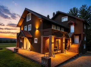 a house with a sunset in the background at Vila Dinka in Lipovac