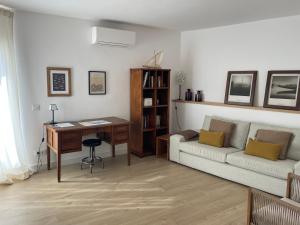a living room with a couch and a desk at Apt Es Poal - Des Puig in Cadaqués