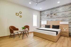 a bedroom with a bed and a table and chairs at Heritage Villa in Ludhiana