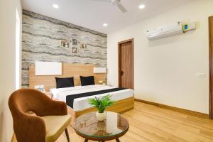 a bedroom with a bed and a table and a chair at Heritage Villa in Ludhiana +21 photos