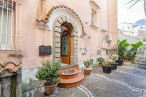 a building with a table and potted plants on a street at Domus Almaré in Minori