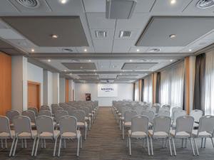 a room with rows of chairs and a screen at Novotel Brescia Due in Brescia +161 photos