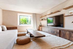 a bedroom with a bed and a table and a tv at Boucle d'Or in El Mtougui