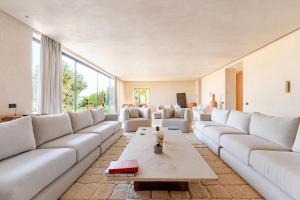 a large living room with white couches and a table at Boucle d'Or in El Mtougui
