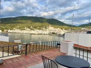 a balcony with a table and chairs overlooking a body of water at Apt Es Poal - Des Puig in Cadaqués