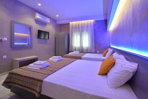 a hotel room with two beds with towels on them at GARBIS Μπακάλης Θεοχάρης in Leptokarya