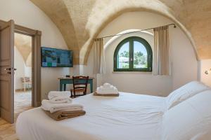 a bedroom with a white bed with towels on it at Masseria Gorgognolo in Ostuni +136 photos
