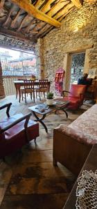 a living room with couches and tables and a stone wall at Dal Ciavatin in Paesana +19 photos