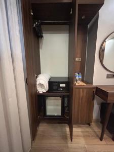 a small closet with a microwave and a mirror at Basilis Hotel in Istanbul