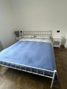 a bedroom with a bed with a blue blanket at Casa delle vele in Valmadrera