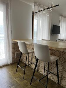 a kitchen with a table and two white chairs at Casa delle vele in Valmadrera