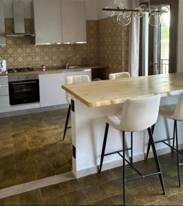 a kitchen with a wooden table and white chairs at Casa delle vele in Valmadrera