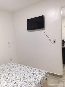 a bedroom with a bed and a flat screen tv on a wall at Henri Karam in Brumadinho