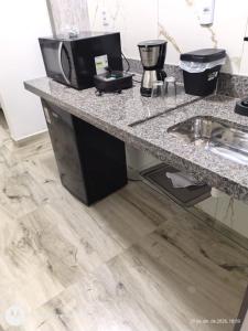 a kitchen with a counter top with a sink at Henri Karam in Brumadinho