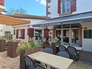 a patio with tables and chairs in front of a restaurant at Gîte chez Maritxu in Saint-Étienne-de-Baïgorry