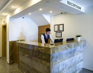a man standing at a reception desk in a lobby at My Marin Otel in Turgutreis