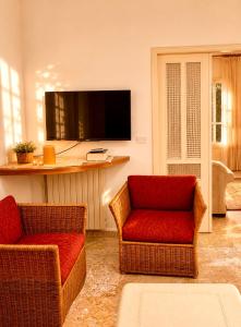 a living room with two chairs and a flat screen tv at Spacious Mountain House In Sehayleh in Ḩayy ash Shabbūq