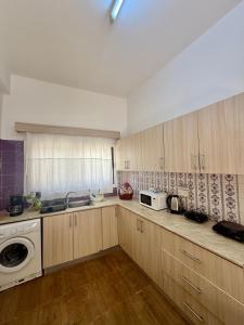 a kitchen with wooden cabinets and a washer and dryer at Arsinoe Guest House in Famagusta +8 photos