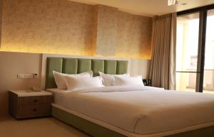 a bedroom with a large bed with white pillows at Novosol Lux- A Premium Hotel Near Airport in Jaipur