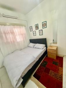 a bedroom with a white bed and a window at Arsinoe Guest House in Famagusta