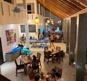 a group of people sitting at tables in a restaurant at Lum Residence in Ahangama