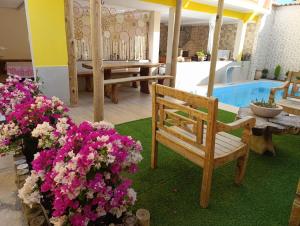 a room with a bench and flowers and a pool at Pousada Mandala in Palmeiras