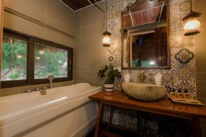 a bathroom with a tub and a sink and a mirror at Tam Coc Lion Kings Hotel & Resort Ninh Binh in Ninh Binh