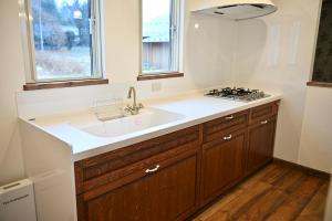 a kitchen with a sink and a stove at Maison de L in Hokuto +23 photos