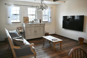 a living room with a tv and a couch and a table at Maison de L in Hokuto