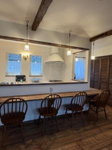 a kitchen with a table and chairs and a counter at Maison de L in Hokuto