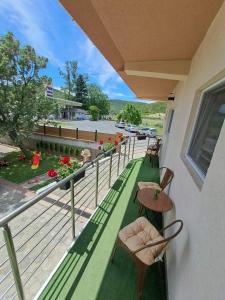 a balcony with chairs and a table and a street at Lazarov Apartments in Nov Dojran