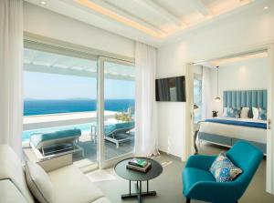 a bedroom with a bed and a view of the ocean at Epic Blue Mykonos in Houlakia