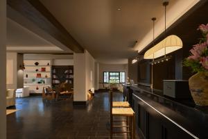 a kitchen with a bar with chairs and a living room at Chengdu Yunduo Bieyuan 云朵 Hotel in Chengdu