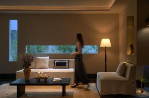 a woman walking through a hotel room with a bed at Chengdu Yunduo Bieyuan 云朵 Hotel in Chengdu