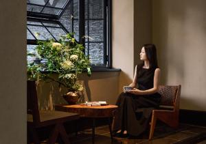 a woman sitting in a chair next to a window at Chengdu Yunduo Bieyuan 云朵 Hotel in Chengdu +149 photos