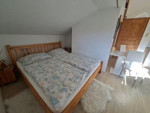 a bedroom with a bed with a wooden frame at Kleines Apartment in Pertitschach