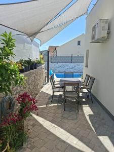 a patio with a table and chairs and the water at Villa Supuk in Vinišće