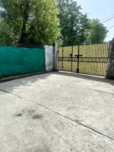 a driveway with a gate and a fence at Beyond the city peaks in Kangra Airport