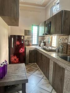 a kitchen with wooden cabinets and a table and a refrigerator at Beyond the city peaks in Kangra Airport