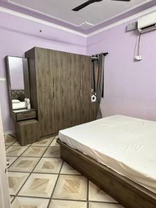 a bedroom with a bed and a cabinet and a mirror at Beyond the city peaks in Kangra Airport +1 photo