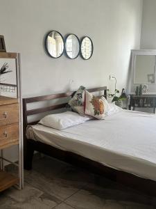 a bedroom with a bed with three mirrors on the wall at Beyond the city peaks in Kangra Airport
