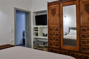 a bedroom with a bed and a large wooden cabinet at Mare Bay in Adamantas