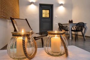 two glass jars with candles sitting on a table at Mare Bay in Adamantas +13 photos