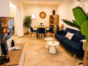 a living room with a blue couch and a table at La Bohème Mouriès in Mouriès
